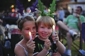 Children participating in a welcoming LED candlelight moment at Carols
